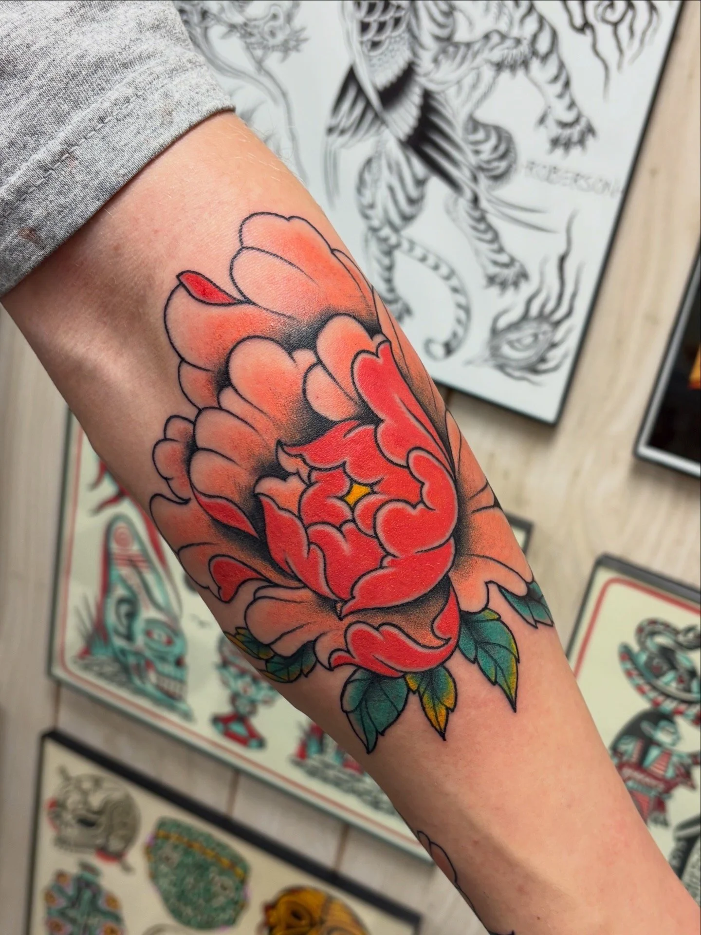 Colorful tattoo of a peony flower on a person's arm, with visible green leaves and black outlines, in a traditional tattoo style. Texas Tech Universitys favorite tattoo shop
Traditional tattoos Lubbock