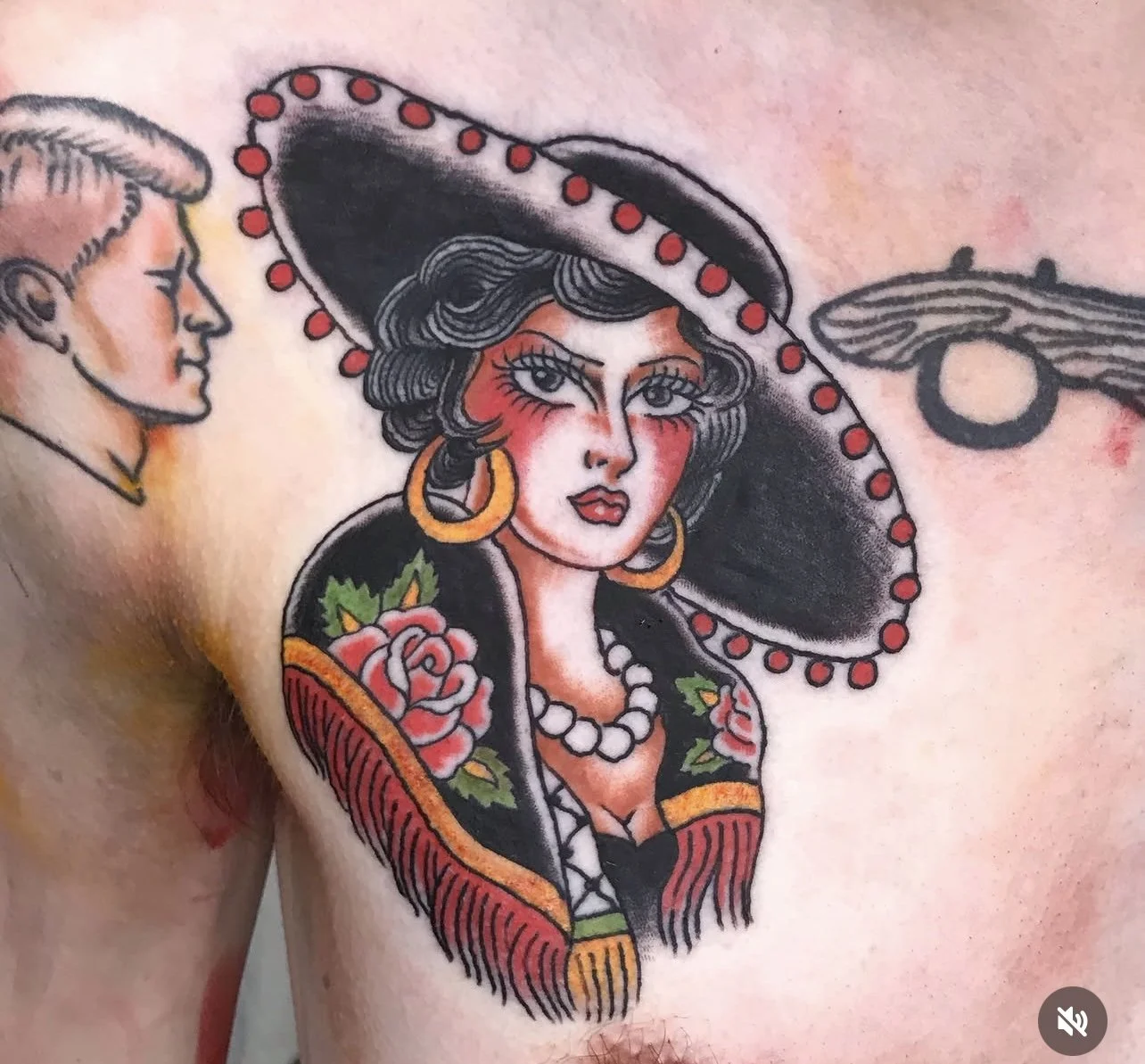 Tattoo of a woman with large earrings, a wide-brimmed sombrero hat decorated with red dots, and a floral shawl.