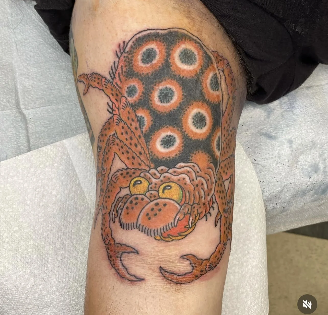 Colorful tattoo of a crab with a detailed pattern on its shell, located on a person's thigh.