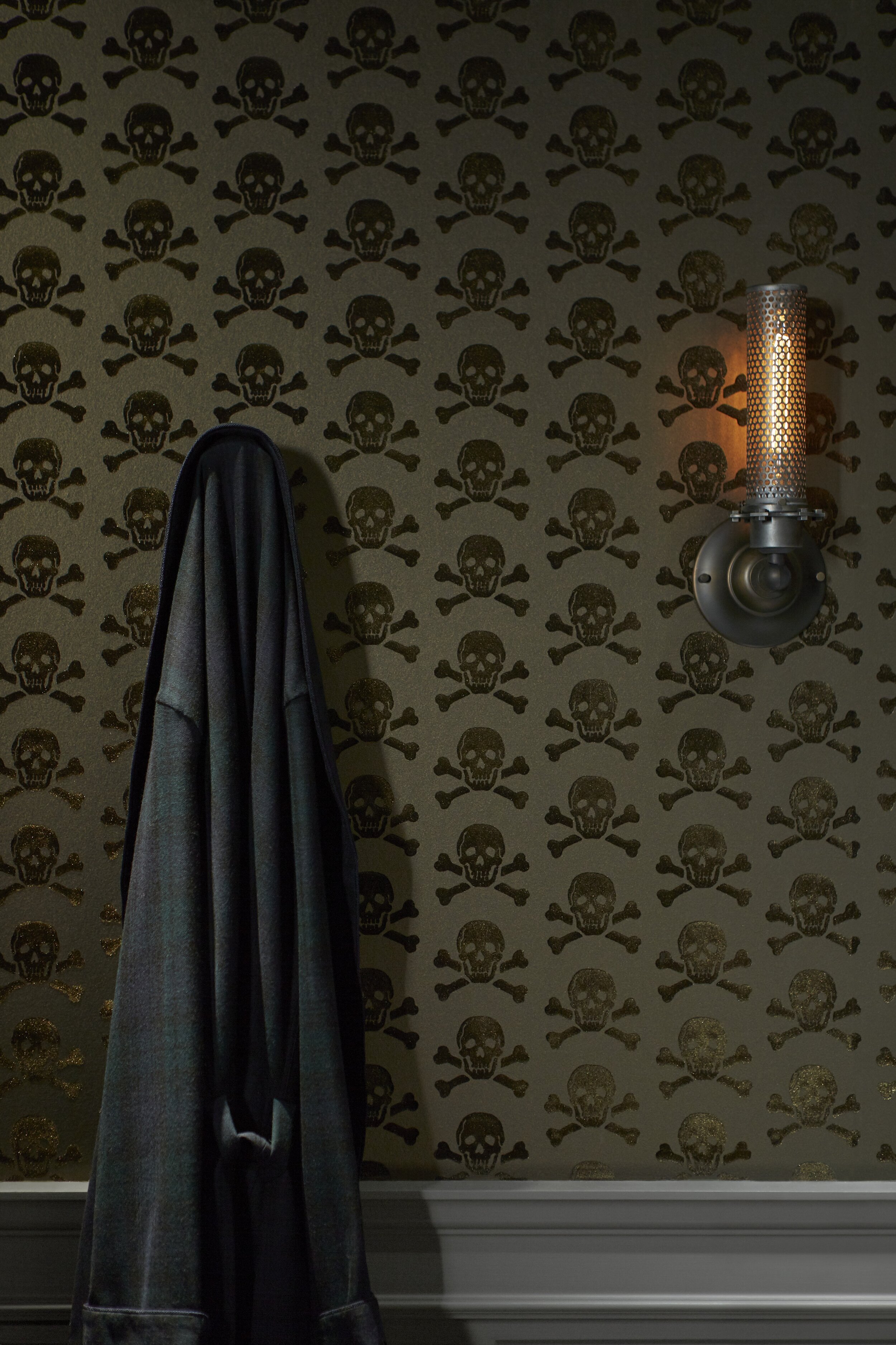 leather jacket and vintage steampunk wall lamp on skulls flock velvet wallpaper