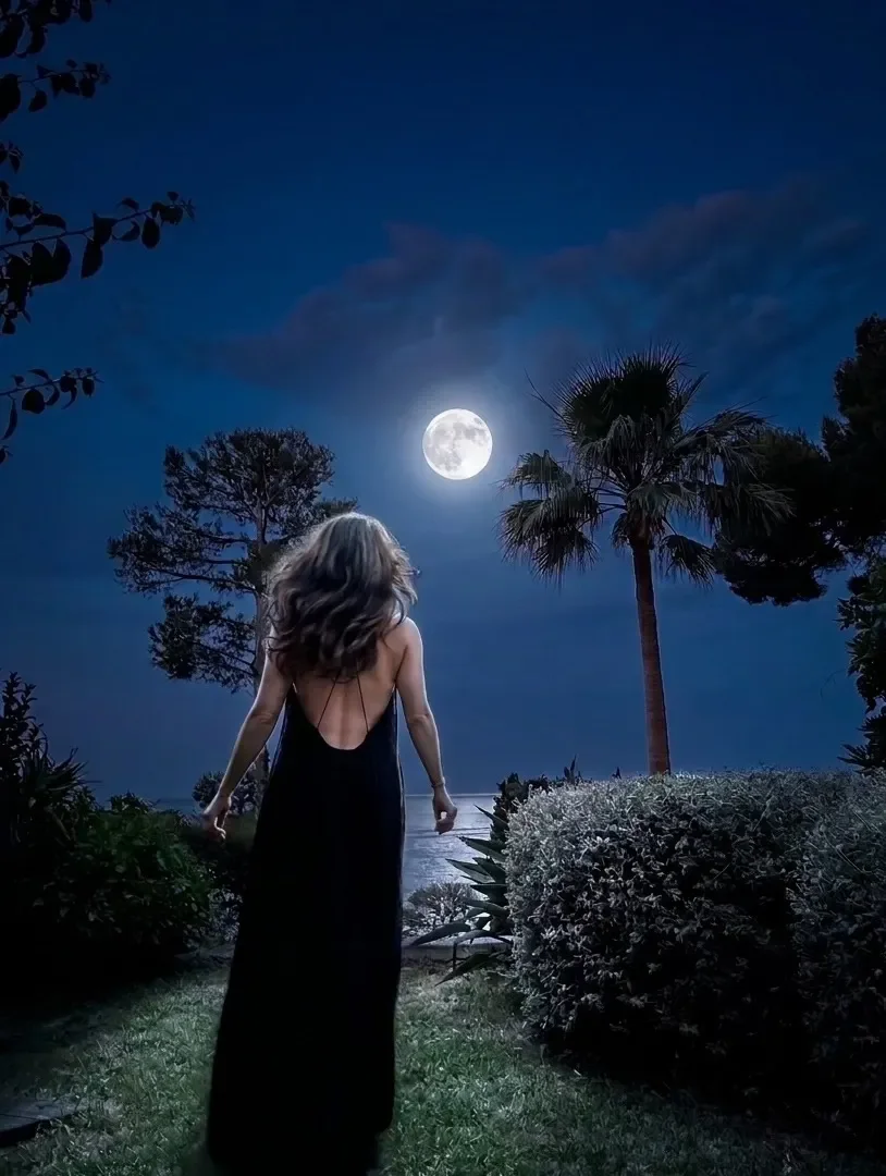 Woman standing beneath a bright full moon at night, reflecting on attachment, truth and emotional clarity.