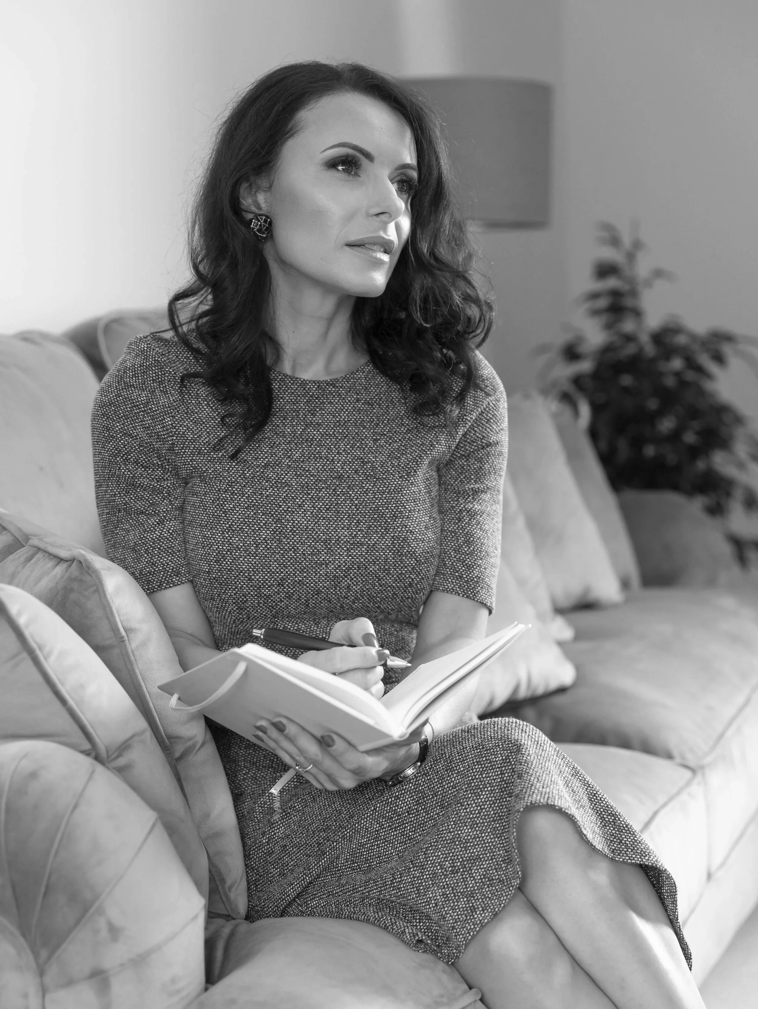 Diana Rogerson seated in an armchair holding an open notebook.