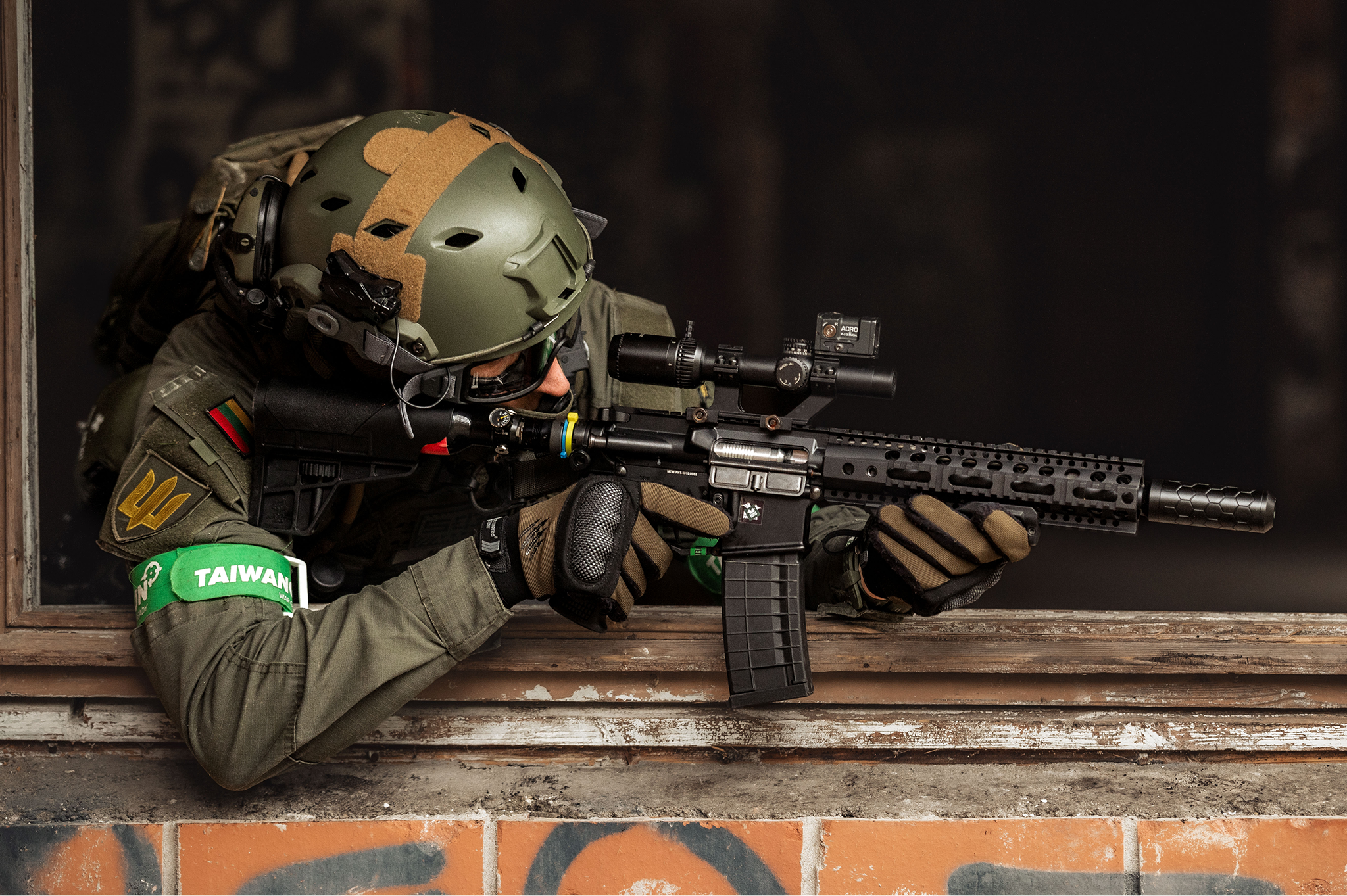 Military soldier aiming with a rifle through a window.