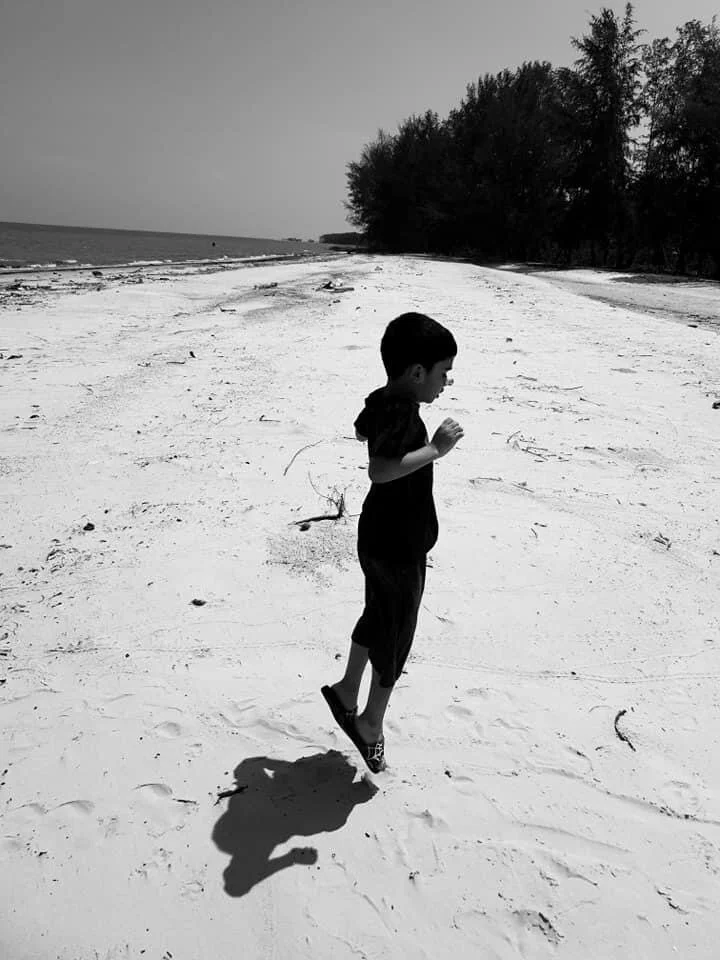 Haans at age 5, jumping on the sad by the beach