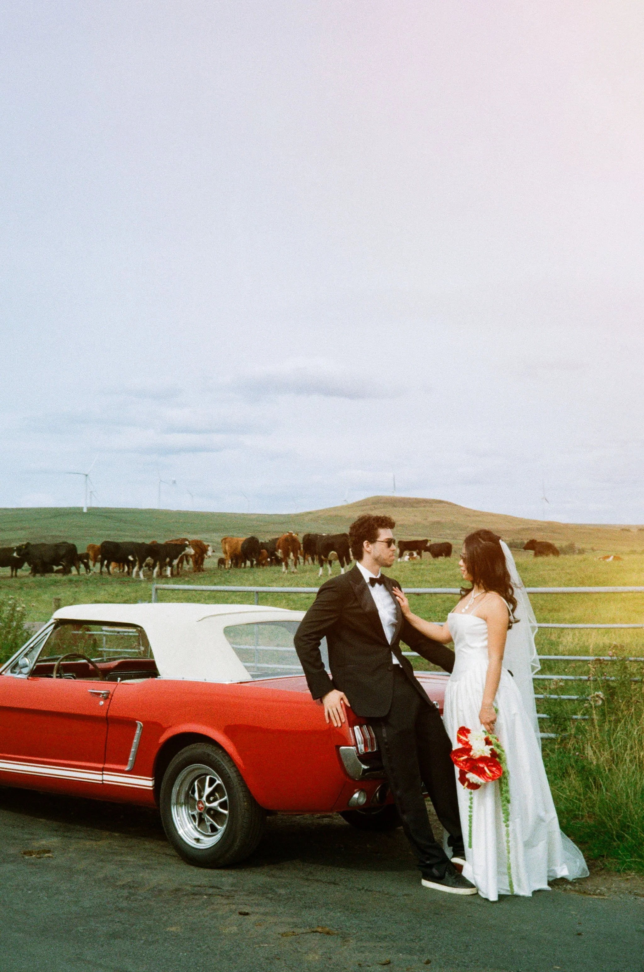 Couple portrait for Nicole and Kaiden engagement with wedding car at Scout Moor Wind Farm