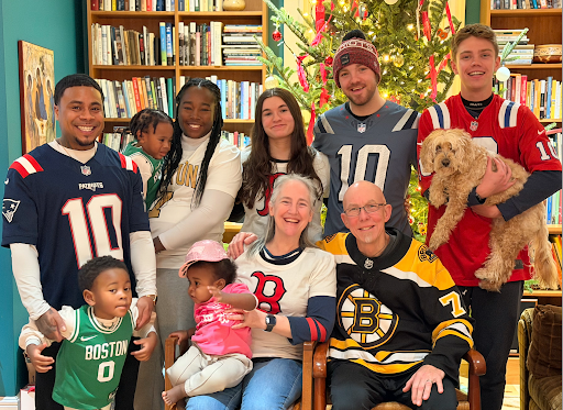 Tara Edelschick with her family, all wearing sports jerseys, and smiling cheerfully.