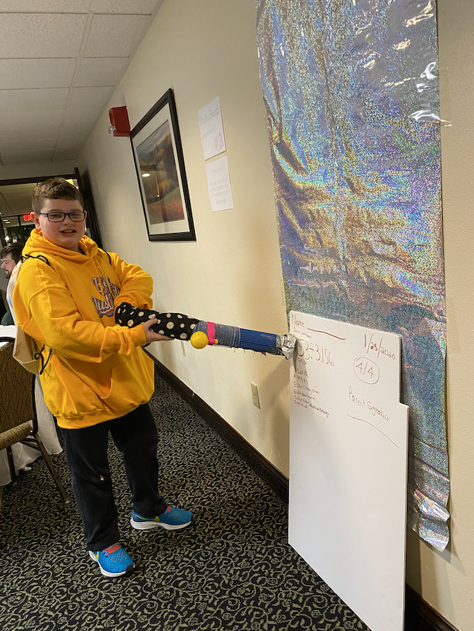 A young participant shows up an invention that solves math problems for you.png