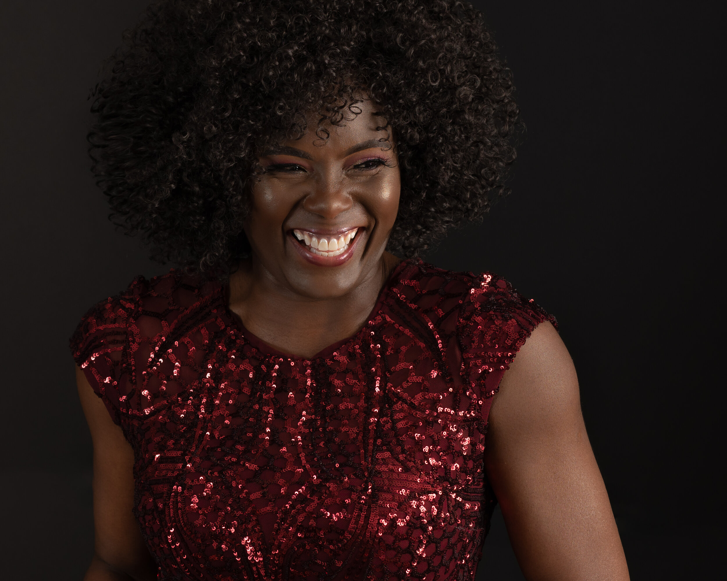 Glamour Headshot of a beautiful African American woman in a Burgundy Dress Showing her beautiful radiant smile