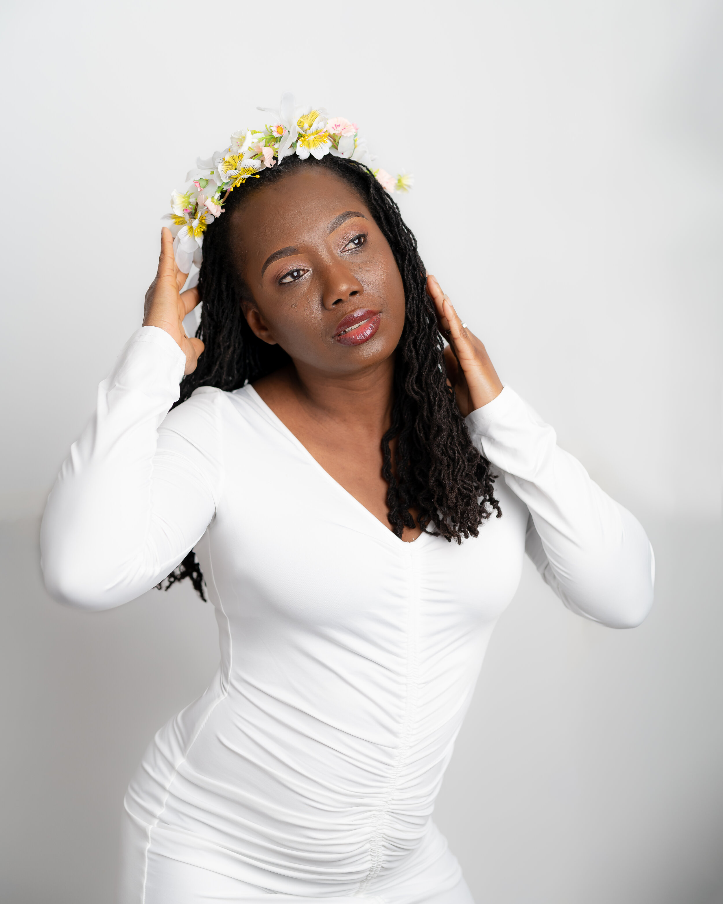 Glamour Portrait of a beautiful Guyanese-American woman in a white dress with a white background
