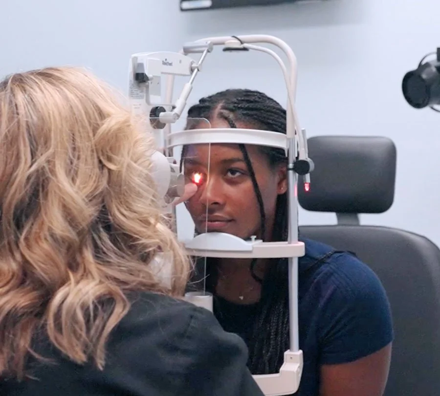 Optometrist conducting an eye exam on a woman in Redding, CA with best eye care service near me