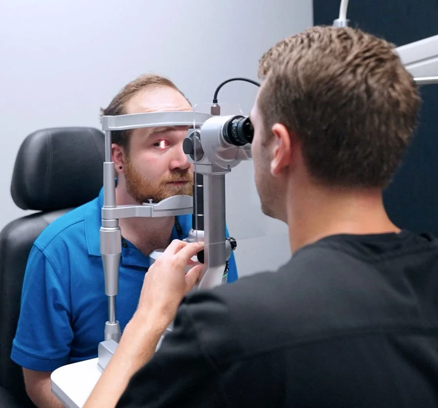 Optometrist performing eye exam for a patient using a slit lamp in a eye care service near me