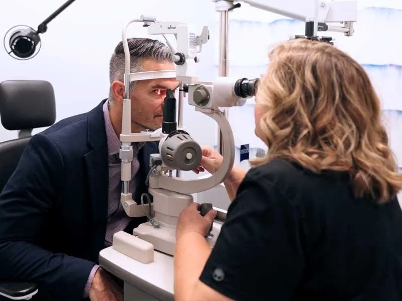An eye doctor examines a patient's eye with a slit lamp at Blink Optometry in Redding, CA