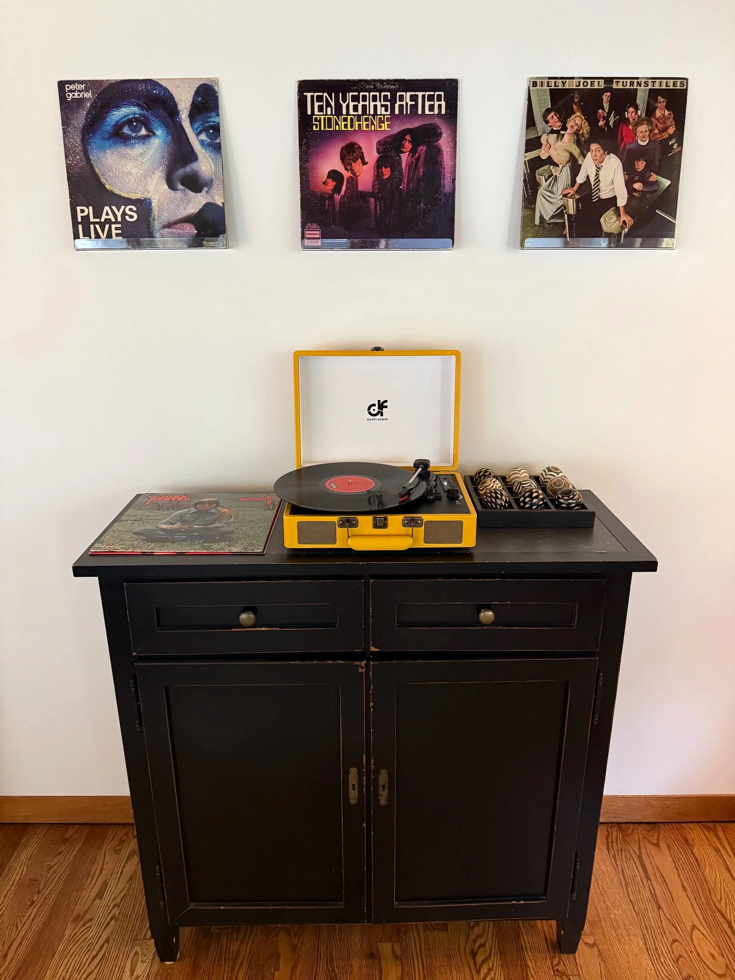 A collection of vintage vinyls with a record player and bluetooth speaker sets the vibe of the space