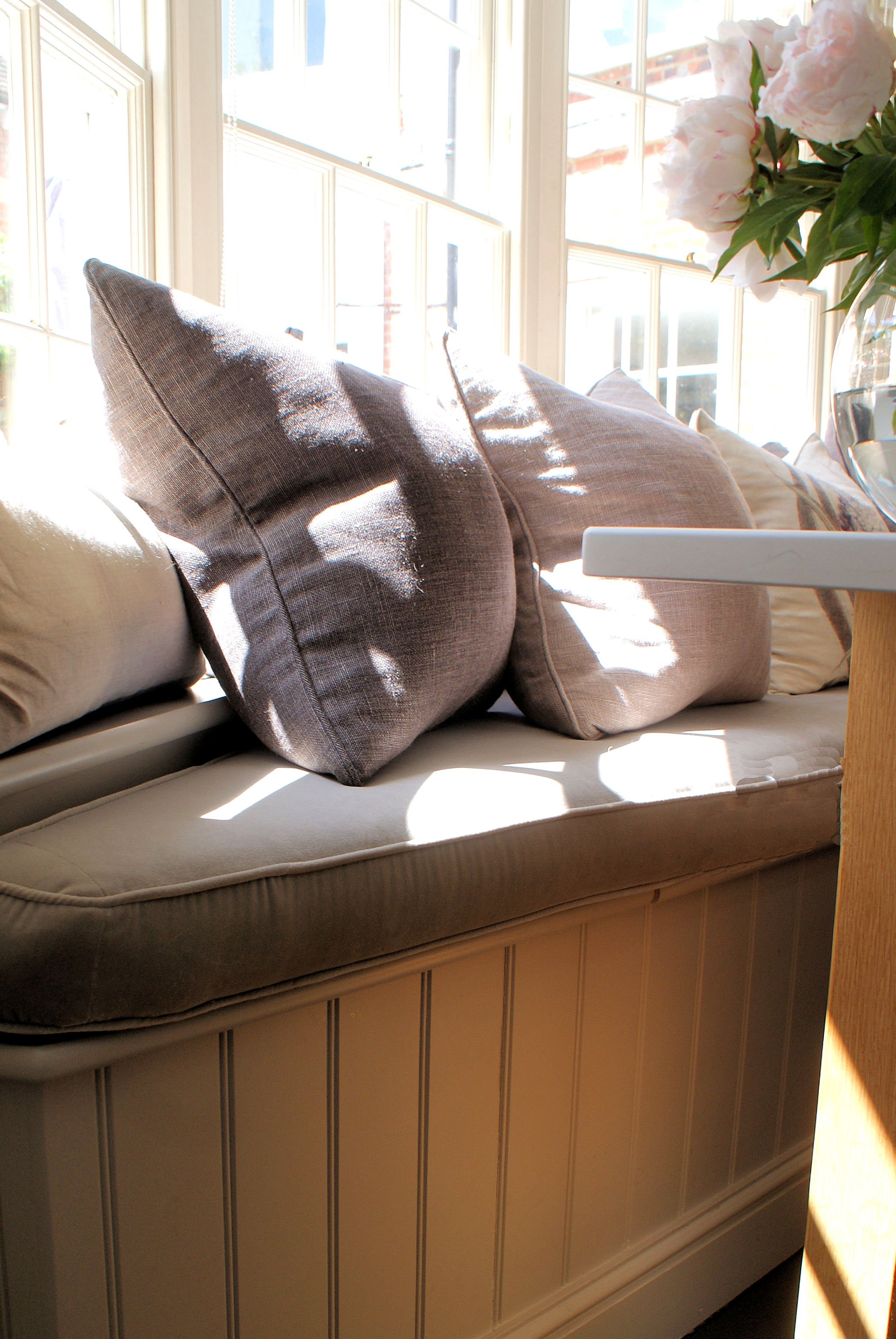  Banquette seating with oversized throw cushions in a combination of floral linen fabrics. 