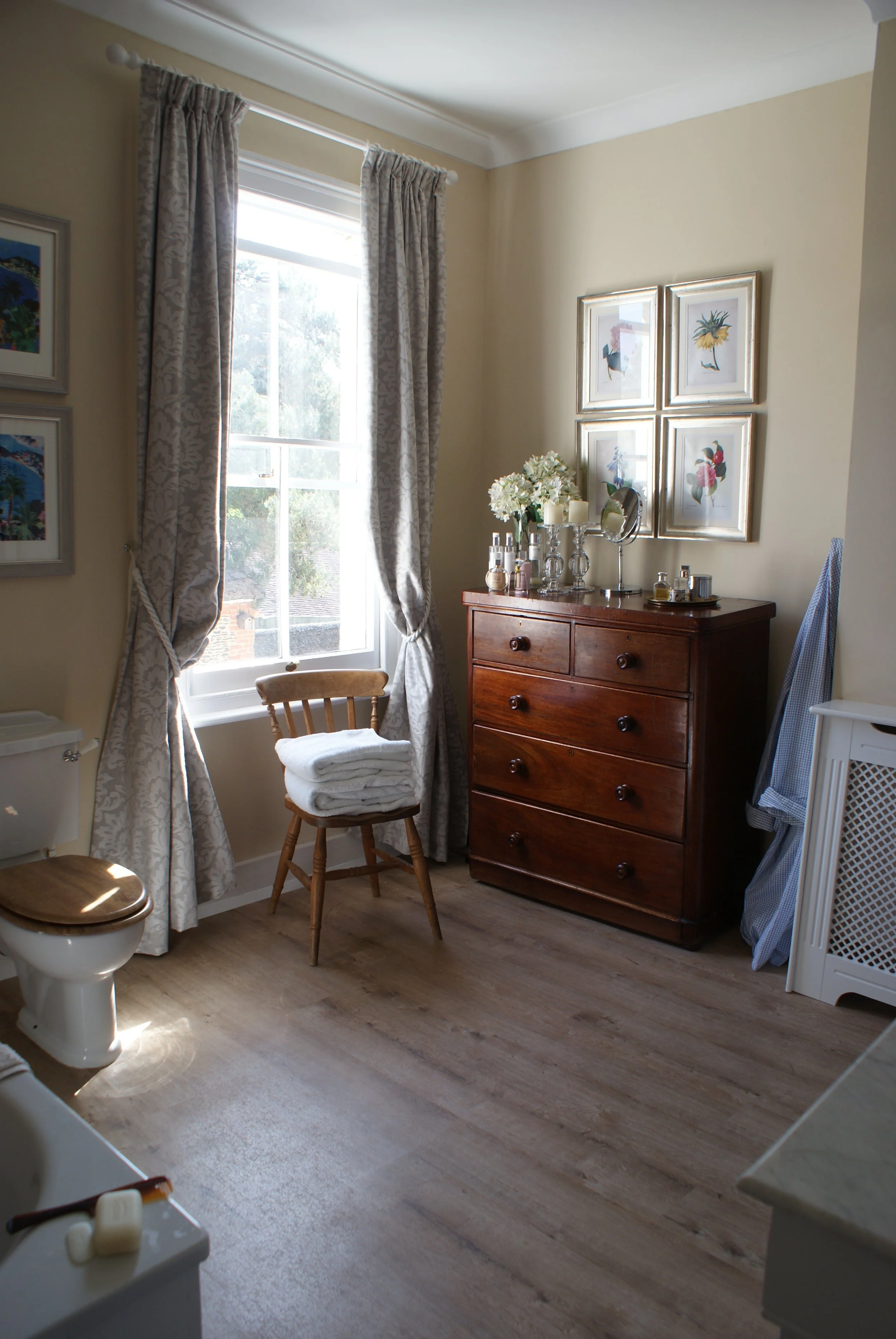  Master Ensuite Bathroom - antique mahogany Victorian tallboy with a set of botanical framed prints above. 