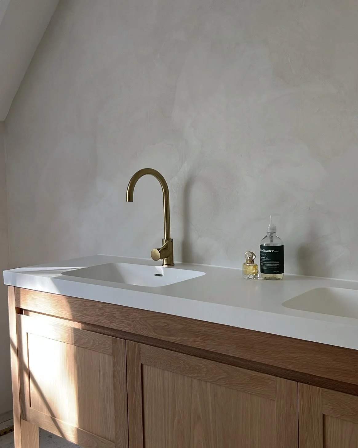 With their velvety finish, these microcement walls introduce a flowing, cloud-like calm that sets the mood for the entire space, creating a subtle rhythm between texture, light and form.