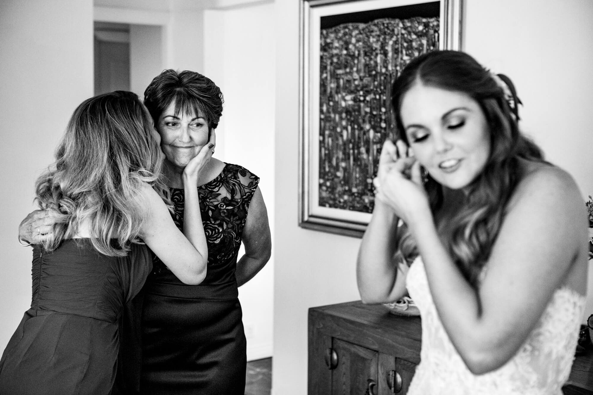 mother looking at her daughter, the bride, getting ready for her wedding