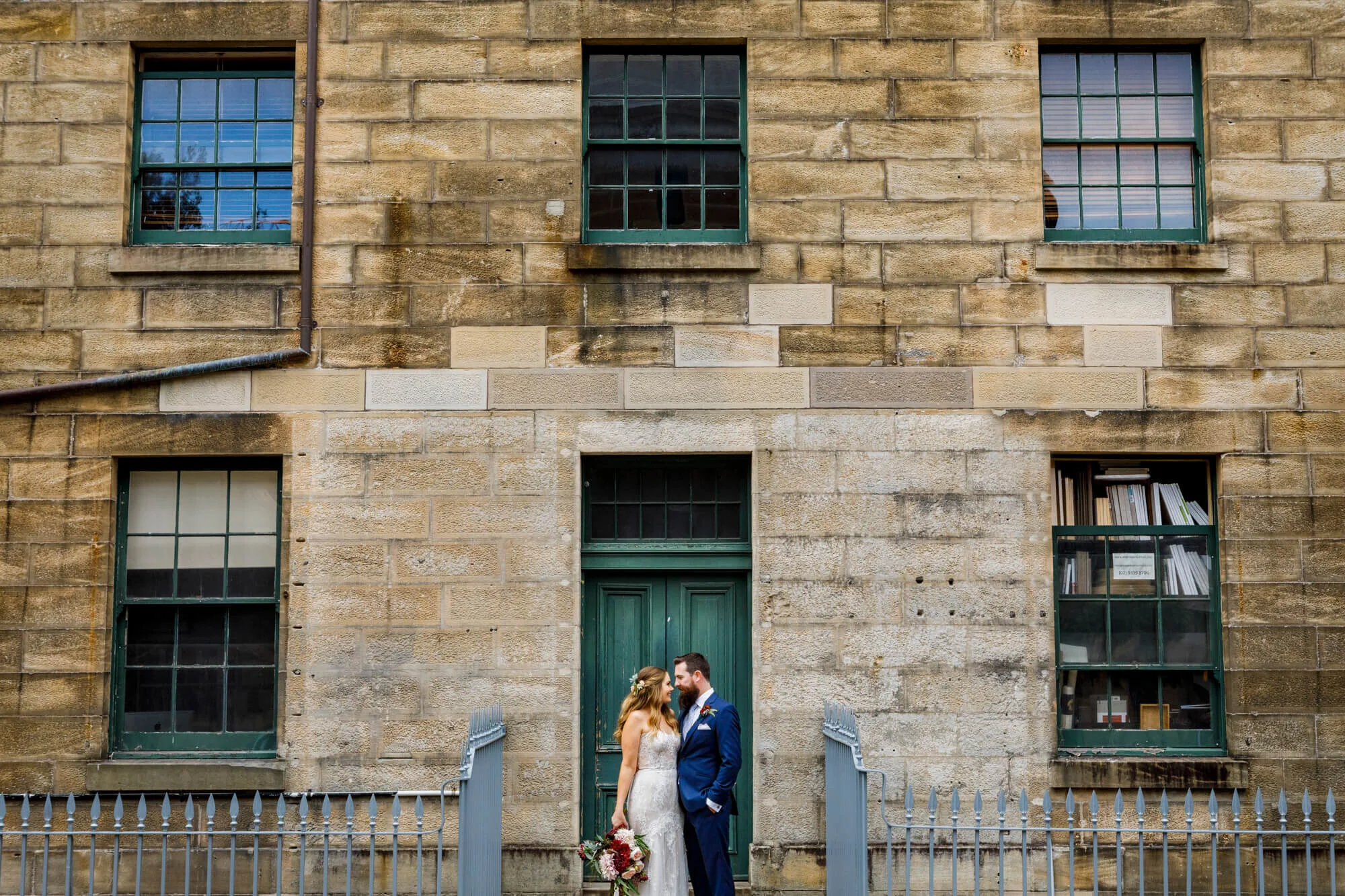 A newly married couple in front of a building at the cell block theatre, Darlinghurst, Sydney