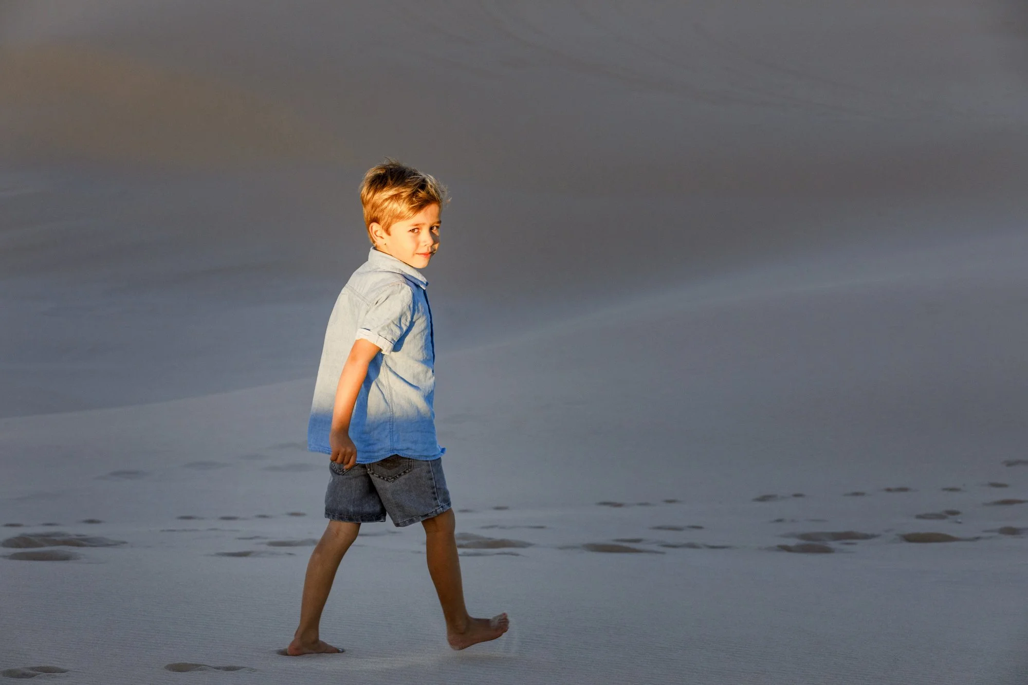 Young boy walking on sand dunes, Anna Bay, Port Stephens