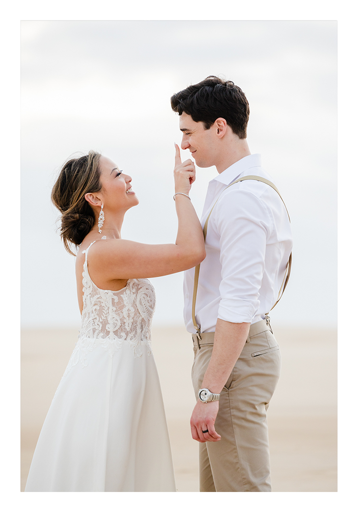 Photography of a newly married couple sharing a sweet moment in Anna Bay's sand dunes, Port Stephens