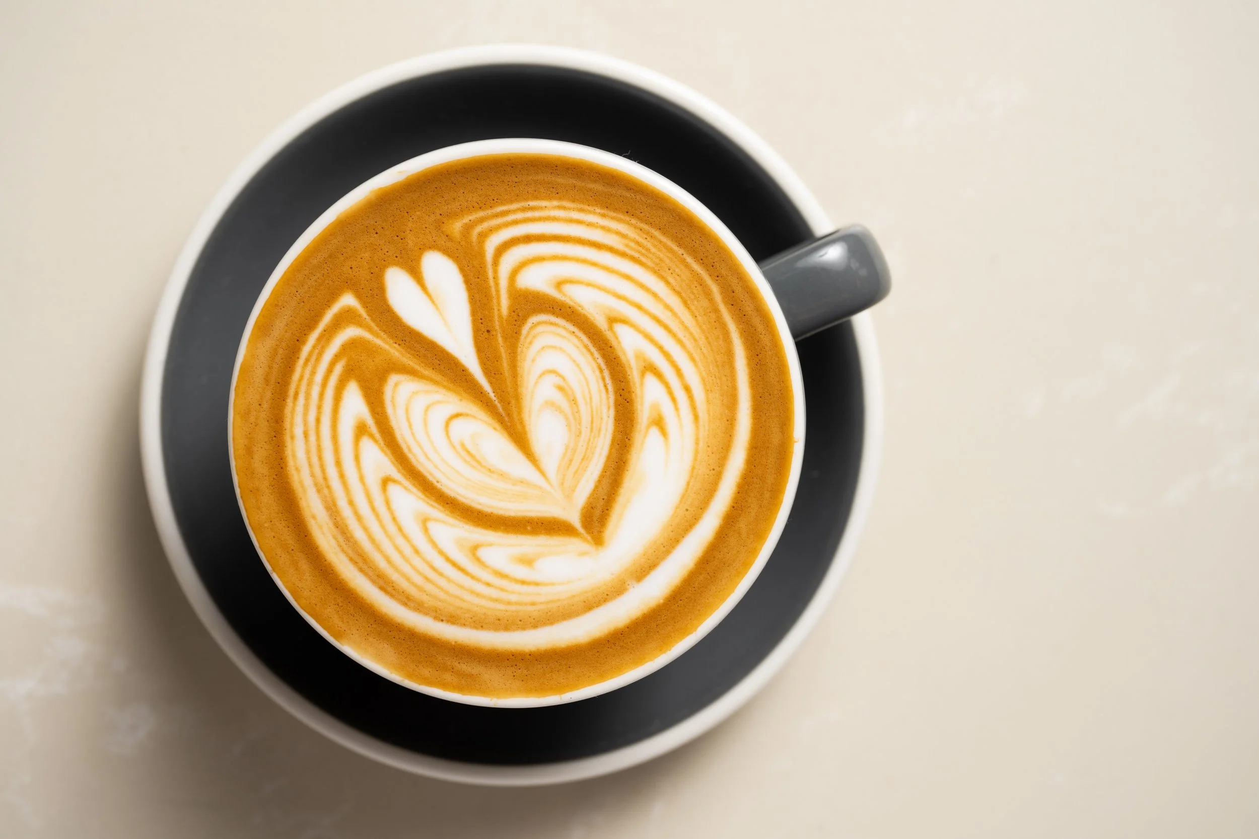 Drip coffee being poured into a ceramic mug.