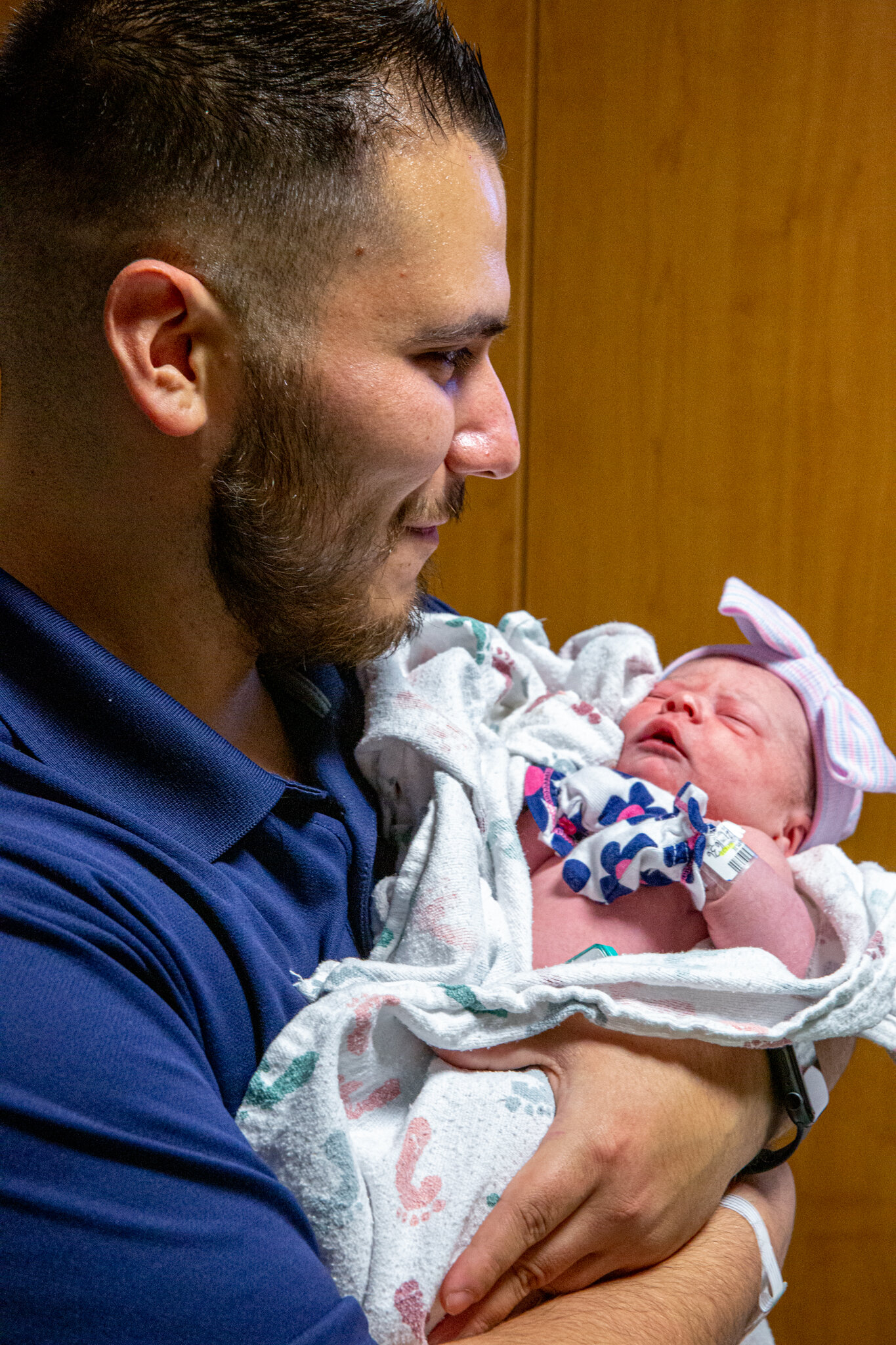 Dad smiling at mom as he holds their baby