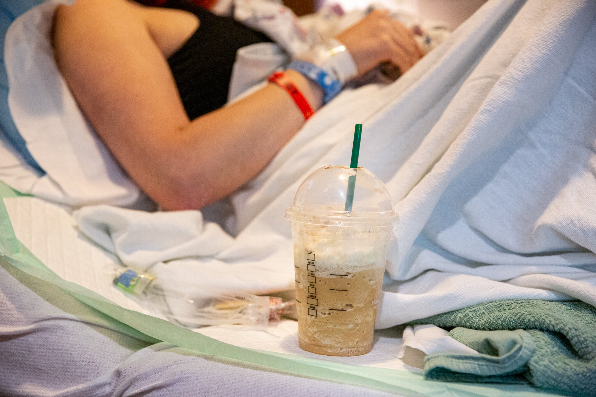 Starbucks cup next to woman in hospital bed
