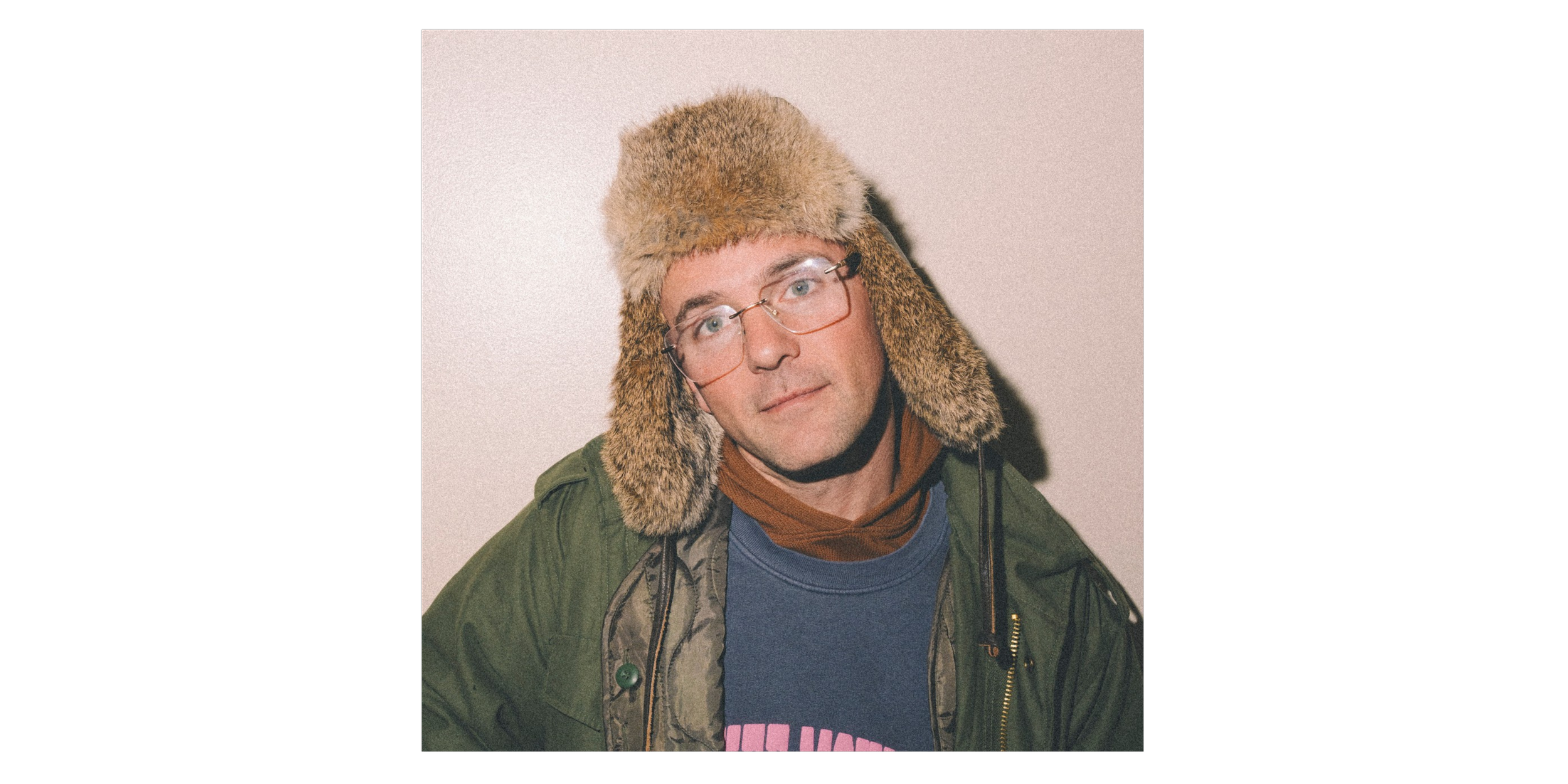 Kosha Dillz wearing a furry hat and green winter coat. Photo by Jeremy Cohen.