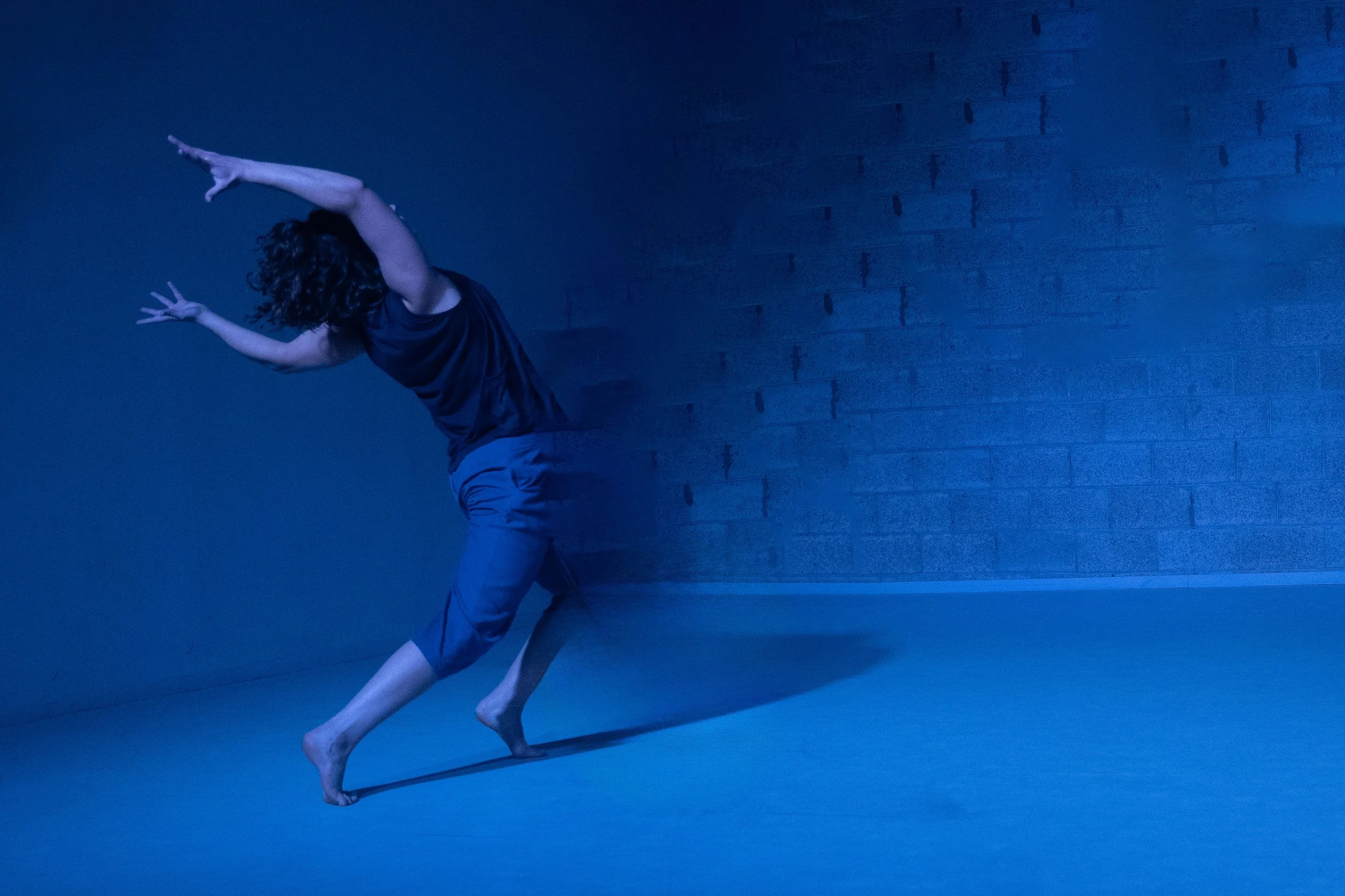 An image of Amit facing a wall and fading into it. Photo by Dan Ben Ari.