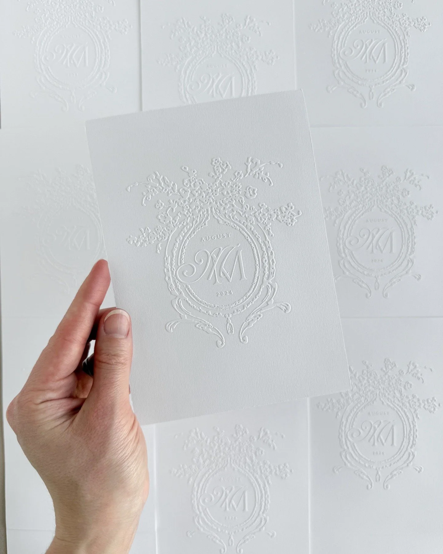 A large-scale emboss of M&amp;M's monogram on the backside of their letterpressed invitation card. We love to collaborate with our clients and find creative ways to use high-end finishes that will leave a lasting impact on their guests.