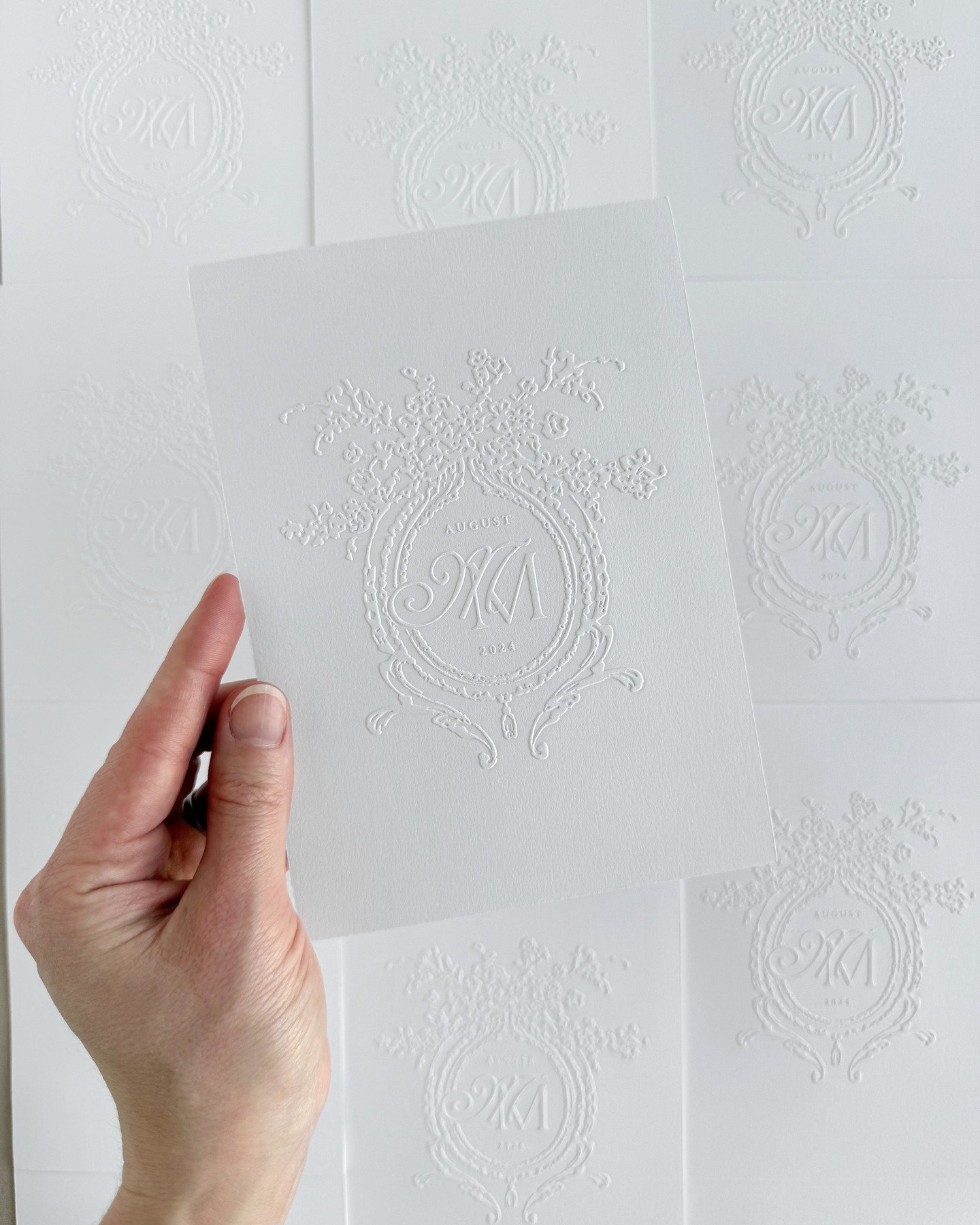 A large-scale emboss of M&amp;M's monogram on the backside of their letterpressed invitation card. We love to collaborate with our clients and find creative ways to use high-end finishes that will leave a lasting impact on their guests.