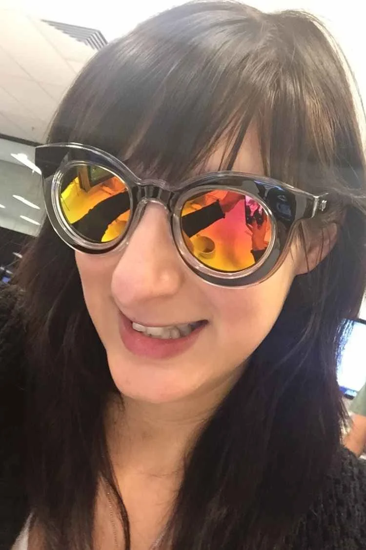 Sarah as a graphic designer wearing funny yellow-shade glasses mucking around at work