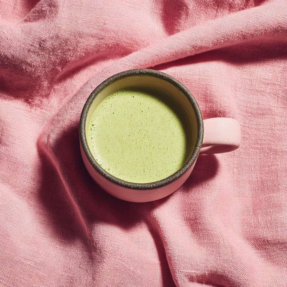 Pink mug filled with hot matcha on top of a pink table cloth representing client testimonial from Leyla Holmes 