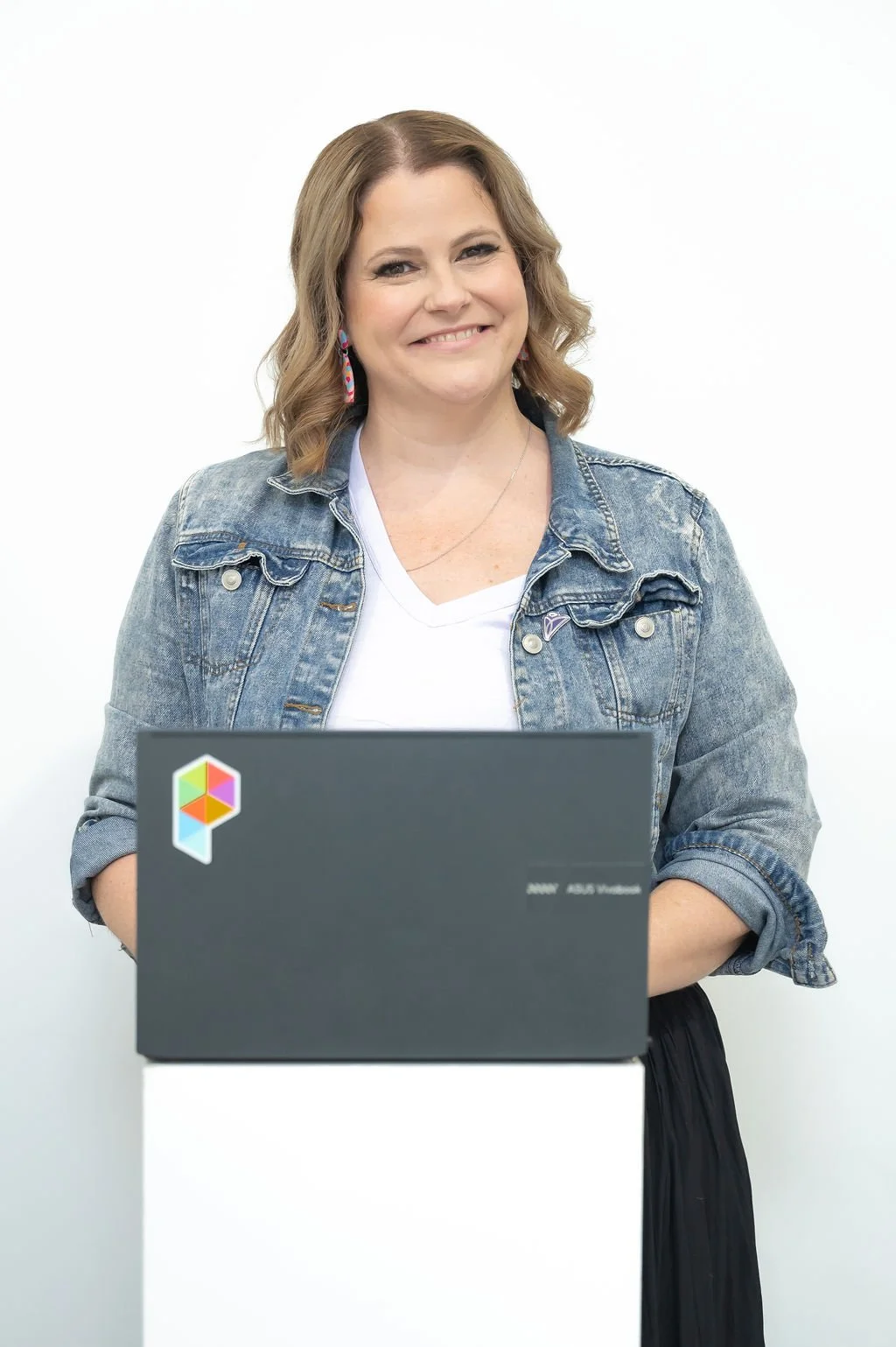 Janelle a Squarespace specialist is smiling in front of an open laptop, wearing casual clothes and looking professional