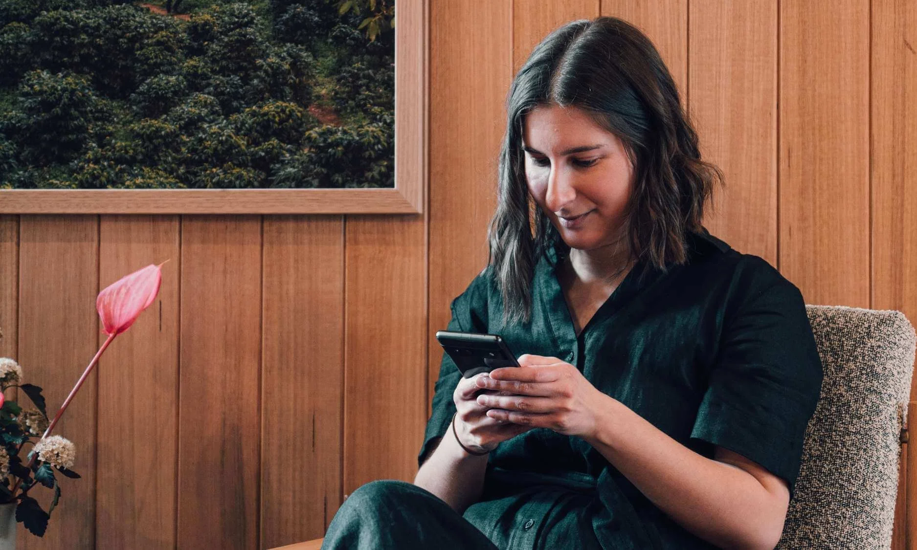 Sarah, a copywriter for creatives sitting in a warm coffee shop scrolling on social media on her phone