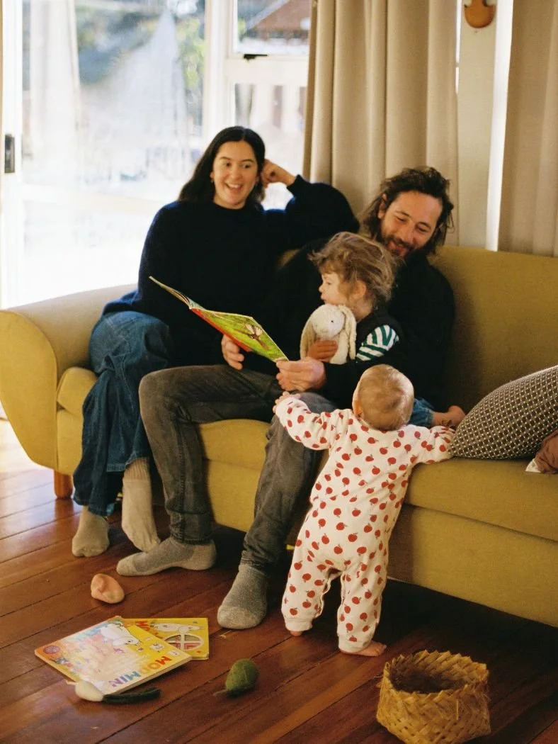 Photo of a family who are Moa Raud's clients, featuring a mother, father and two children on a couch at home