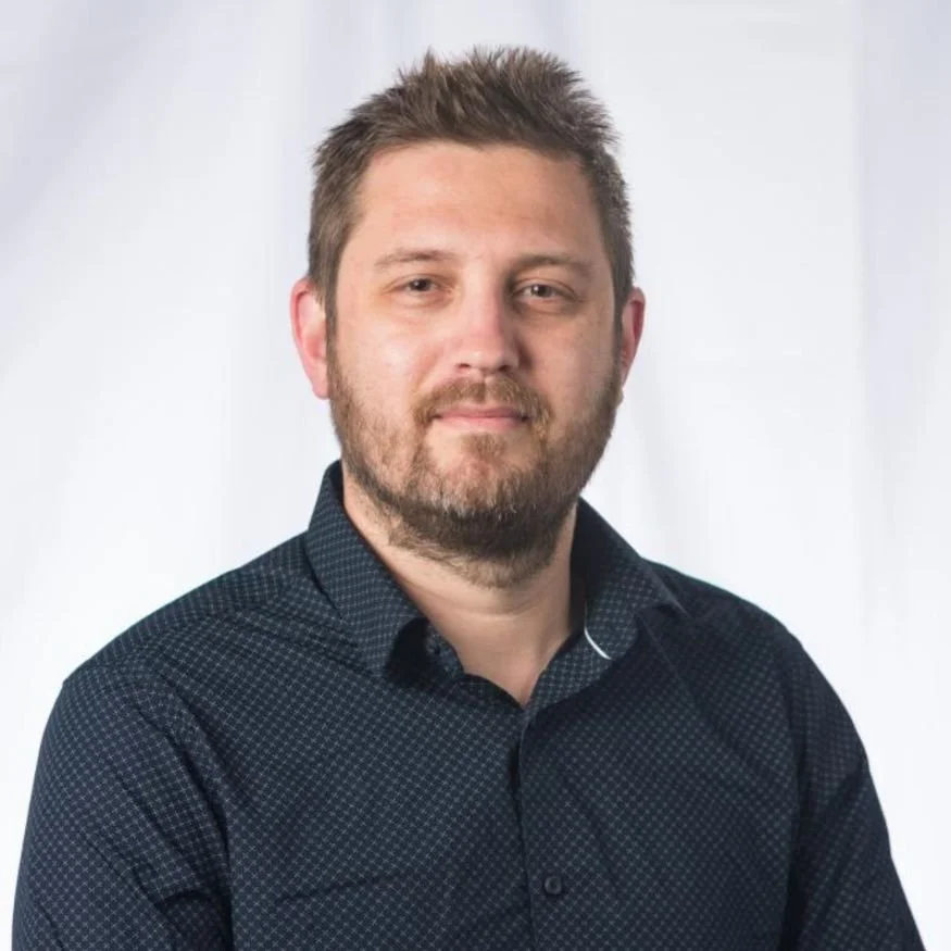 Head shot of Stephen McLachlan, Sarah's client looking professional in a dark button up shirt and a white background