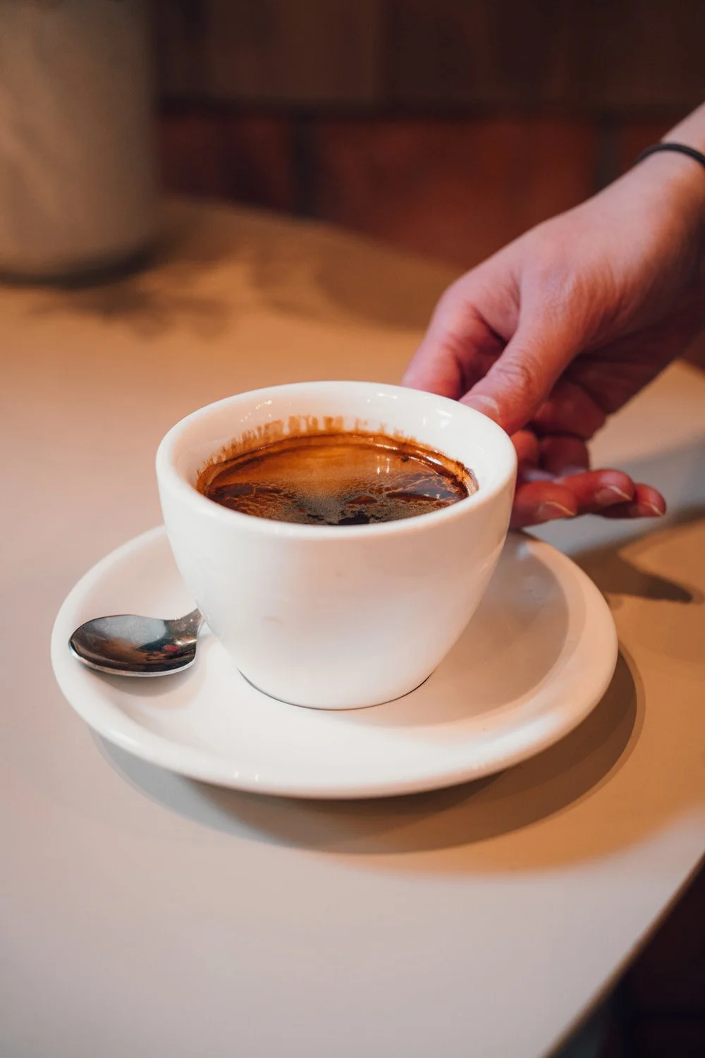 freelance copywriter from Melbourne about to pick up a coffee cup in a lovely cafe
