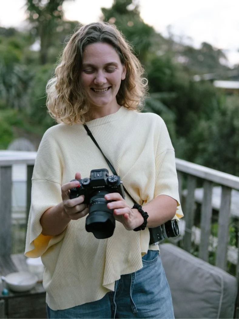Moa Raud looking at her camera with a happy expression on her face, in a lovely outdoor setting