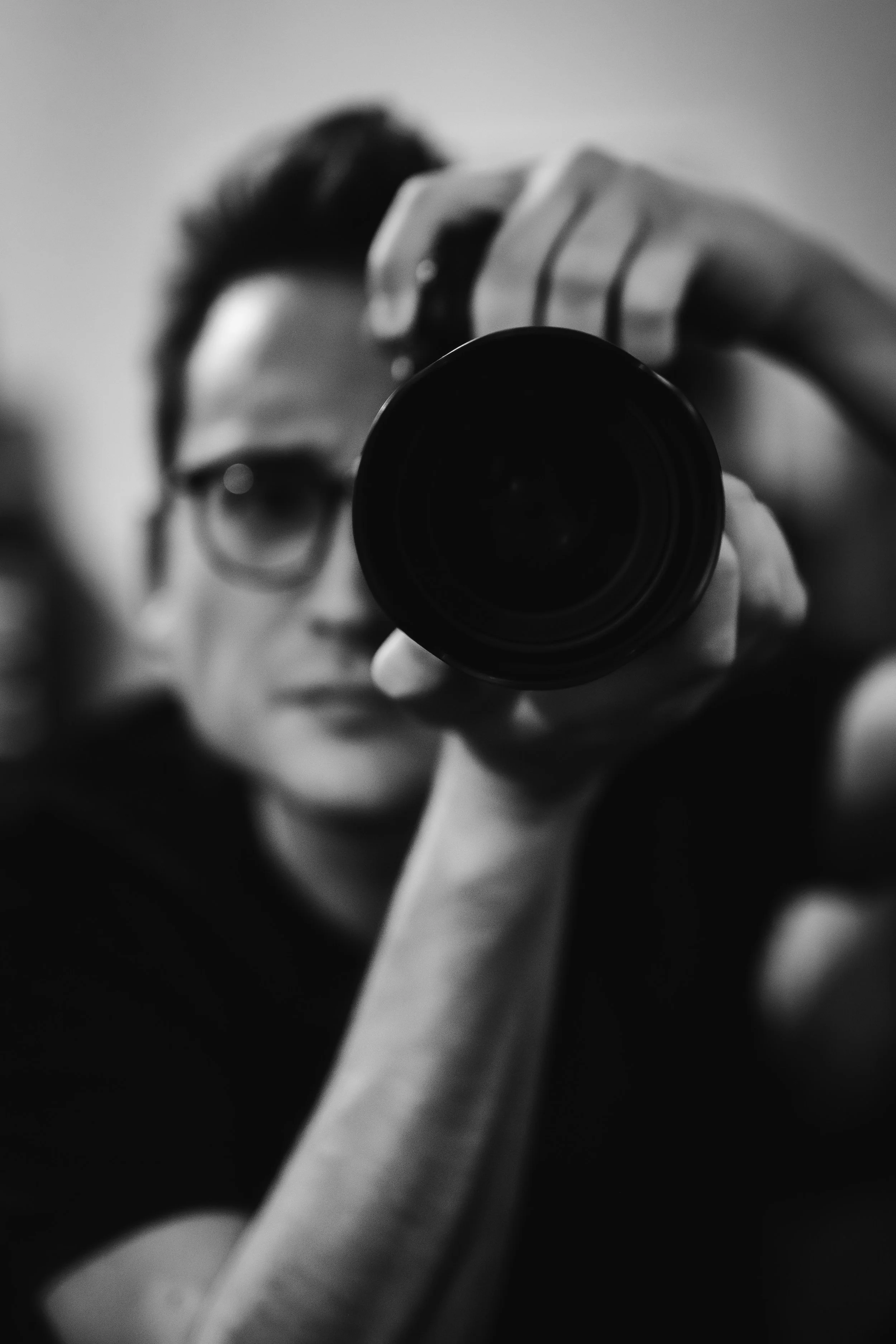 Une tasse de café blanc sur une table en bois avec des ombres et de la lumière naturelle.