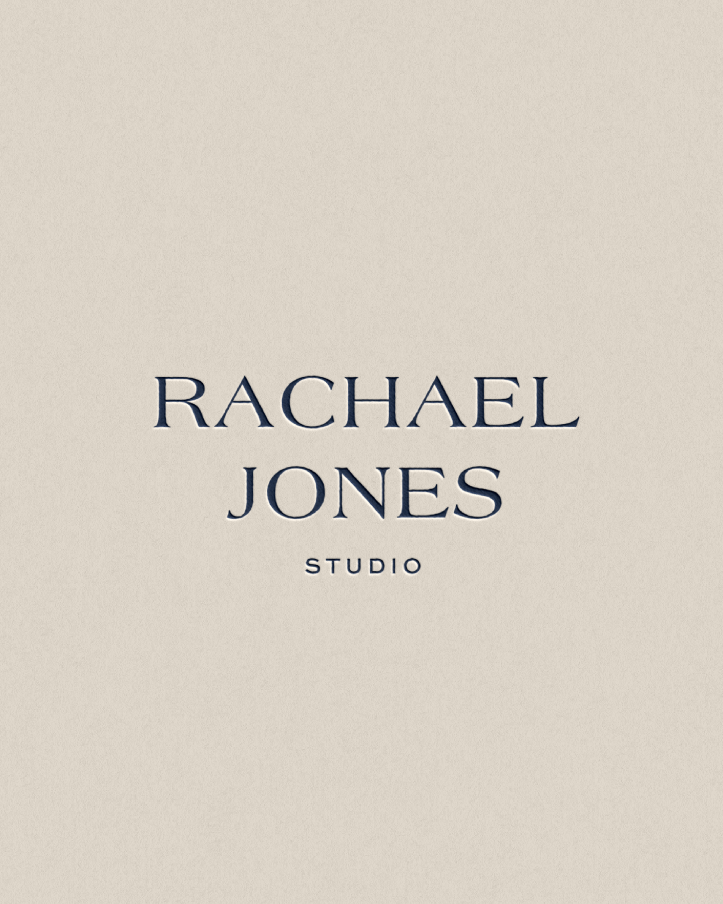 Dark blue debossed wordmark for Rachael Jones Studio on neutral background