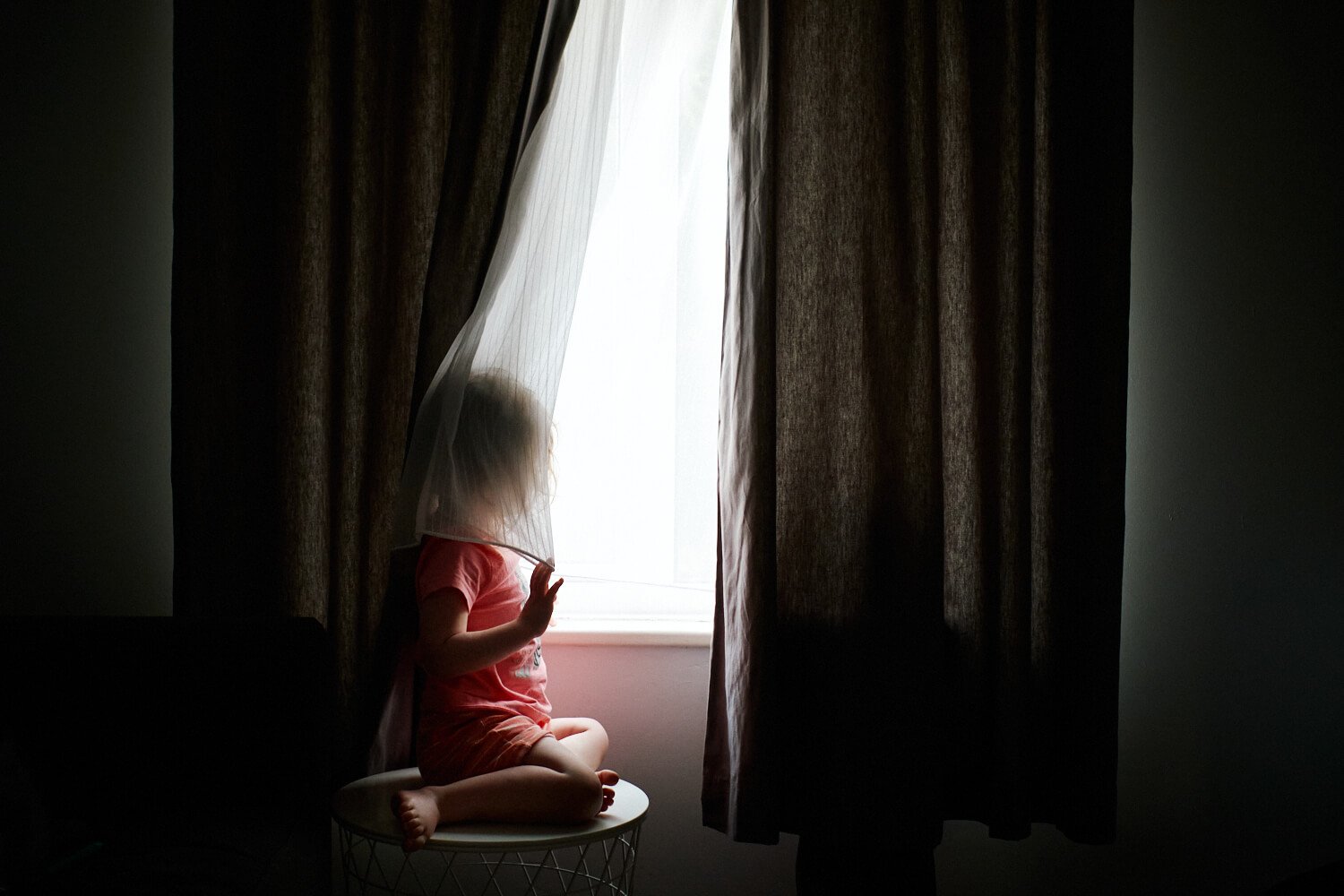 Documentary Family Photography in Dorset - Daisy peeking through the curtains