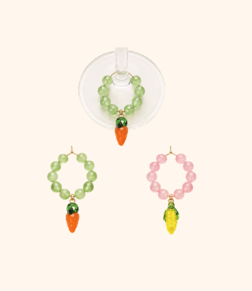 Set of three bead bracelets with small carrot and orange or yellow charm pendants, one bracelet with green beads, one with pink beads, and one with yellow beads, displayed on a white background.