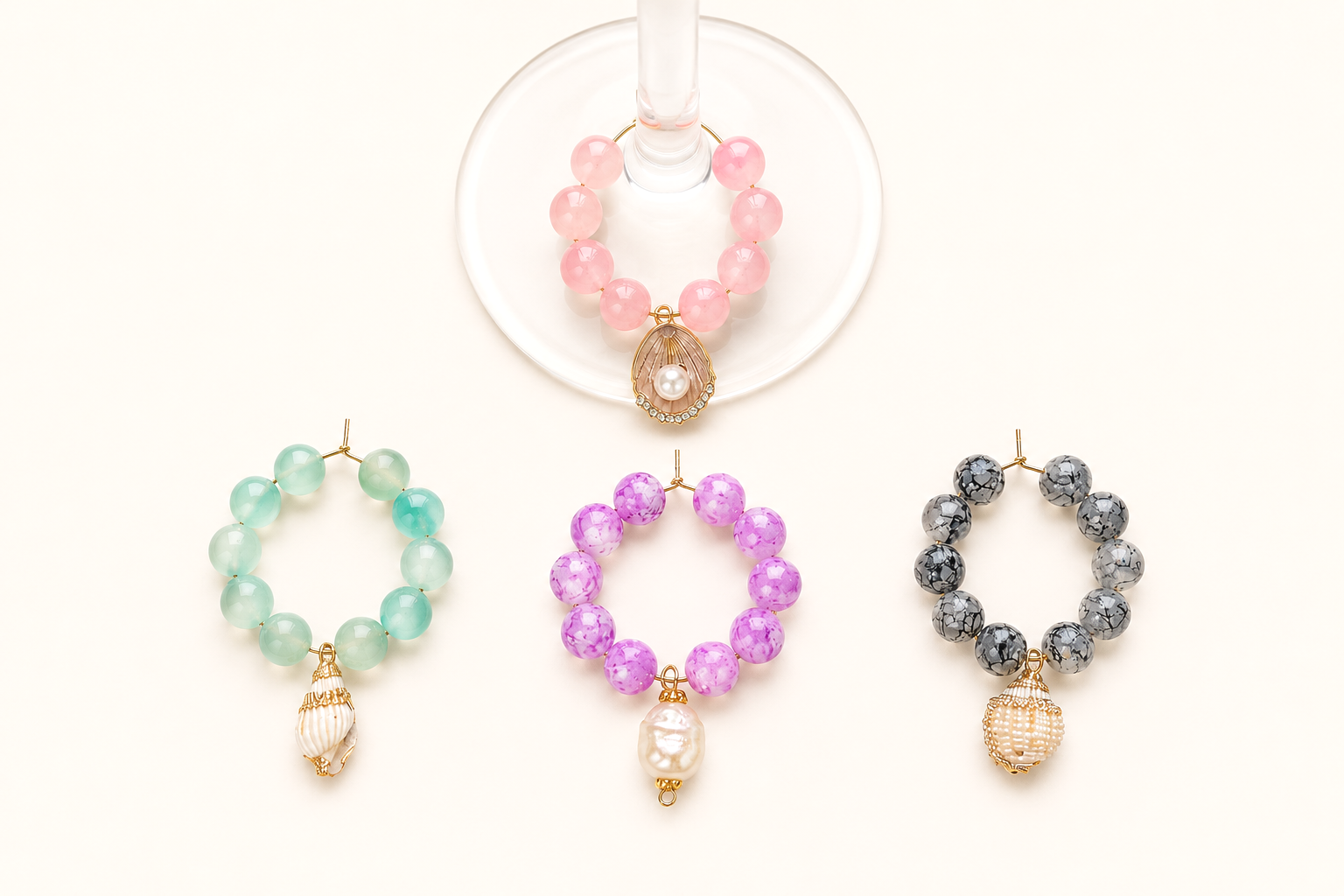 Colorful beaded bracelets with pearl and shell charms on a white background, displayed with a pink beaded bracelet in a glass holder.