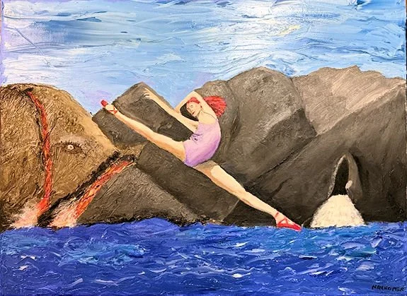A girl in a pink shirt and red hat doing a split on a large rock near the ocean, with waves hitting the rocks and a blue sky in the background.