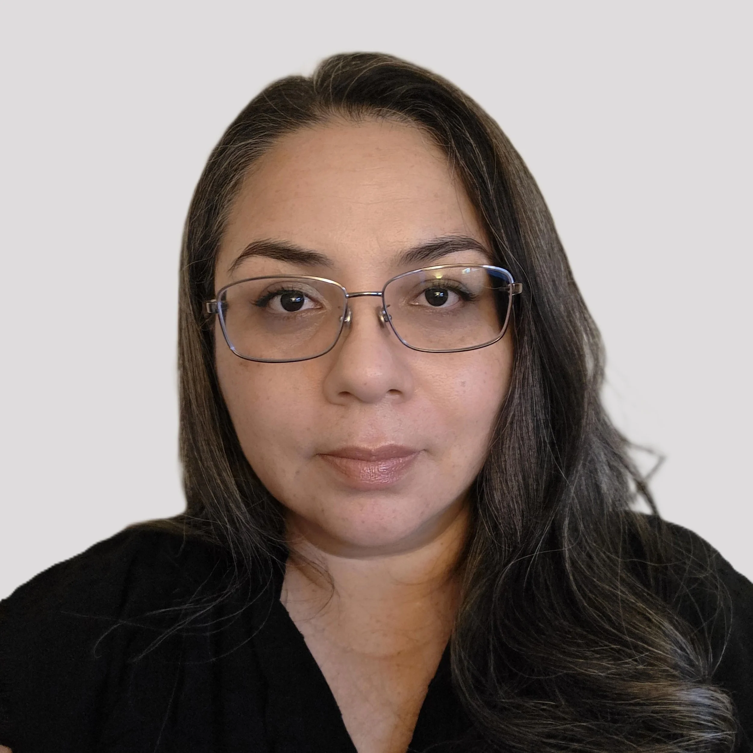 Smiling woman with long dark brown hair wearing glasses and black blouse.