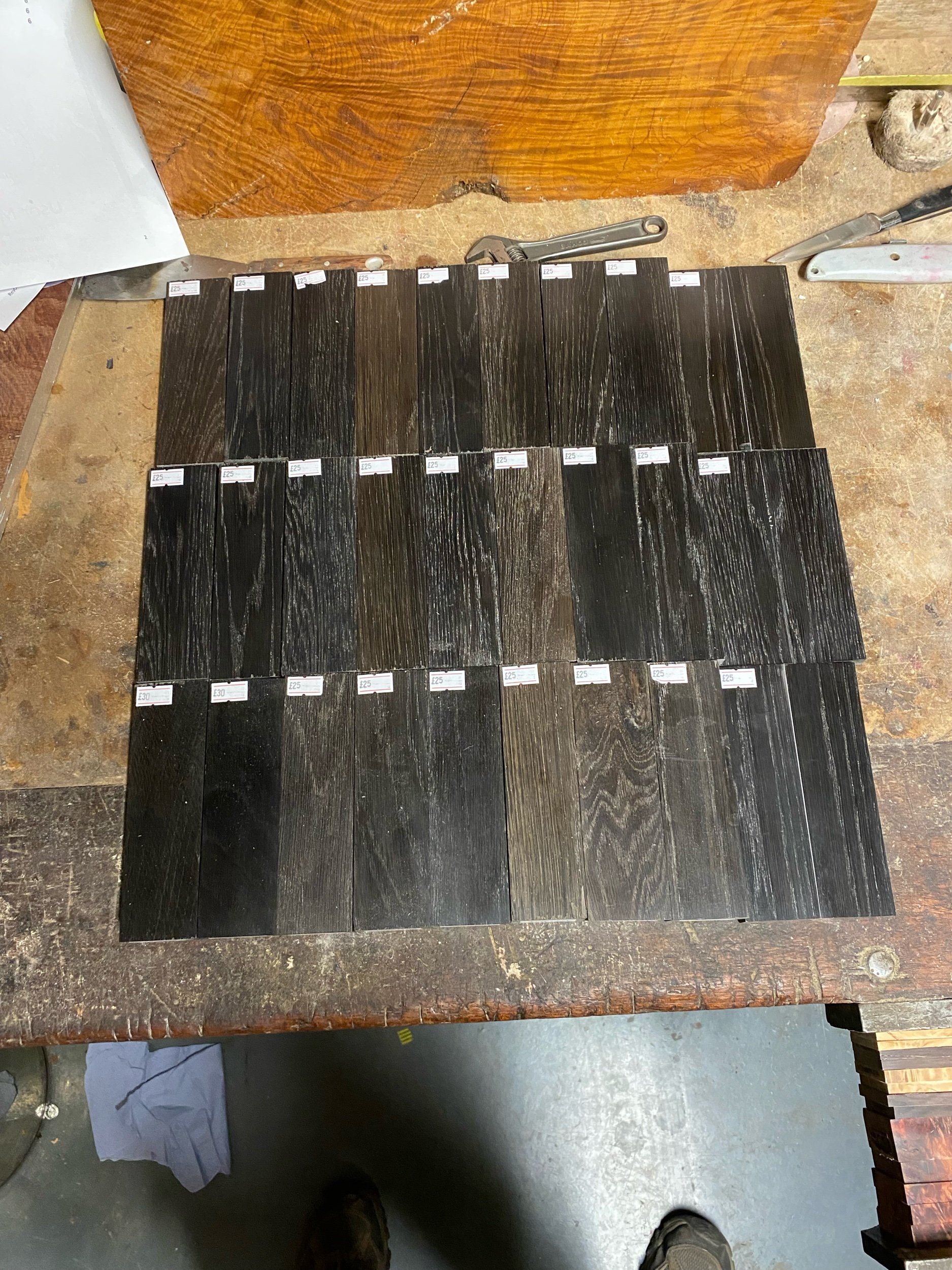 Several dark wood veneer samples arranged on a wooden surface, showing different wood grain patterns and shades.