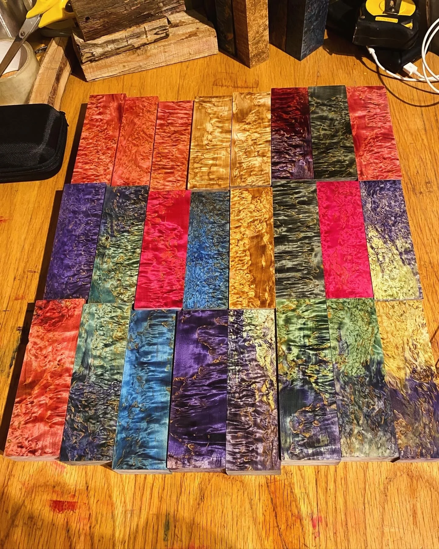 Assorted colored wood blocks with intricate grain patterns displayed on a wooden table.