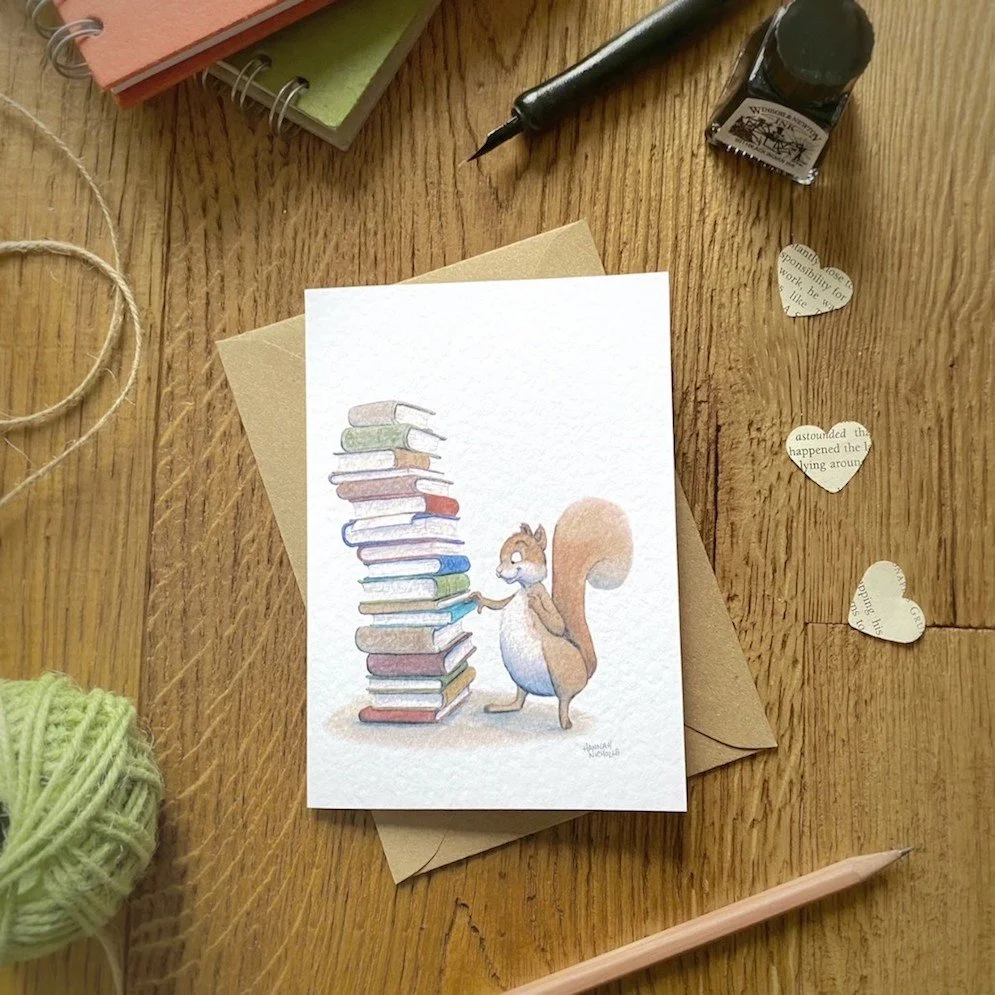 desk flat lay of squirrel and tower of books greeting card by Hannah Nicholls Art