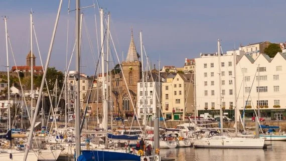 Yachts moored in St Peter Port harbour, Guernsey, seen during a walking tour